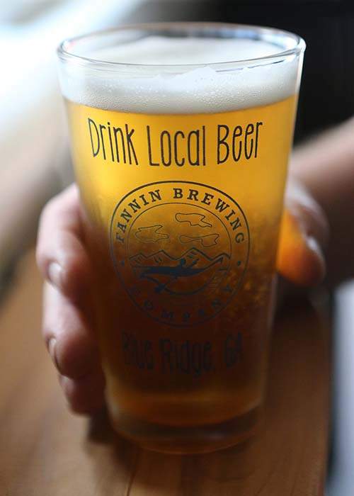 A patron enjoys Chief White Path, a white IPA with lime leaf tea and lemongrass at Fannin Brewing in Blue Ridge. 