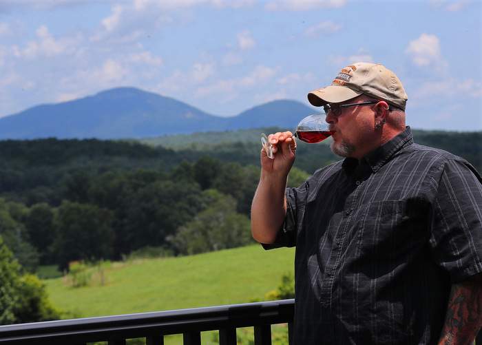 Local resident James Redden, 45, takes in the view of the Appalachian Mountains while tasting wine on the back porch at Kaya Vineyard &amp;amp; Winery in Dahlonega.