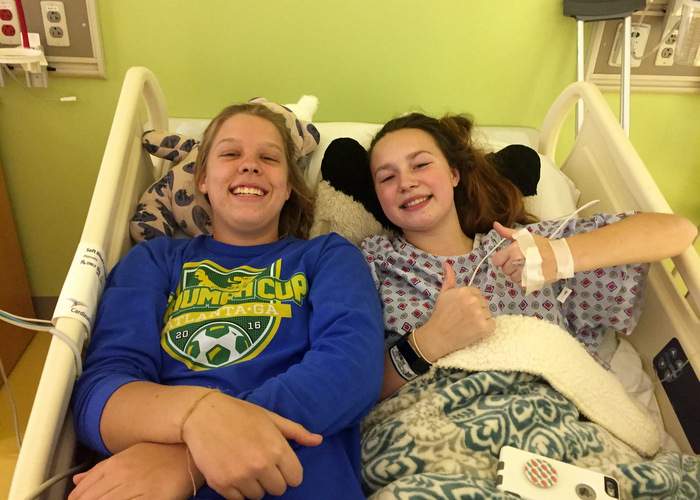 Alex (right) and Annie gets cozy in Alex’s hospital bed after her surgery for Bount disease. CONTRIBUTED BY ANNIE KILPATRICK