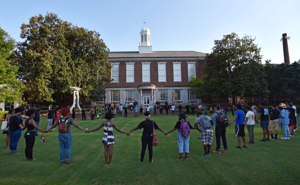 Students and family members of Jamarion Robinson hold hands to pay tribute outside Clark Atlanta University’s Trevor Arnett Hall during a memorial for former CAU student Jamarion Robinson, who was shot and killed by law enforcement July 28, 2016, during an attempt to serve a warrant.PHOTO: Hyosub Shin \/ AJC