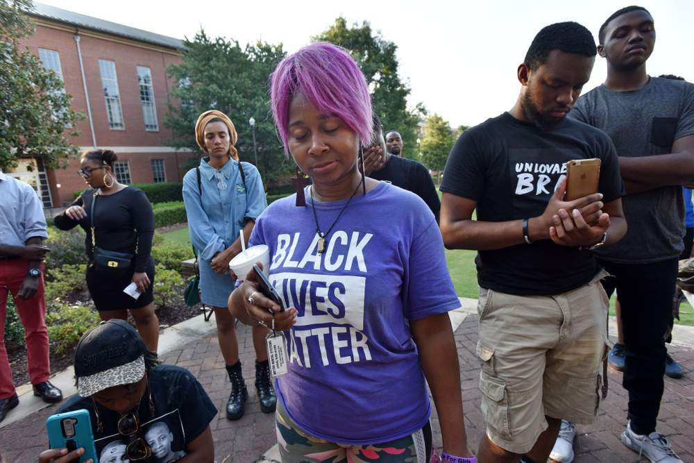 Nicole Borden (foreground) participates in a memorial for former Clark Atlanta student Jamarion Robinson, who was shot and killed by law enforcement July 28, 2016, during an attempt to serve a warrant.PHOTO: Hyosub Shin \/ AJC