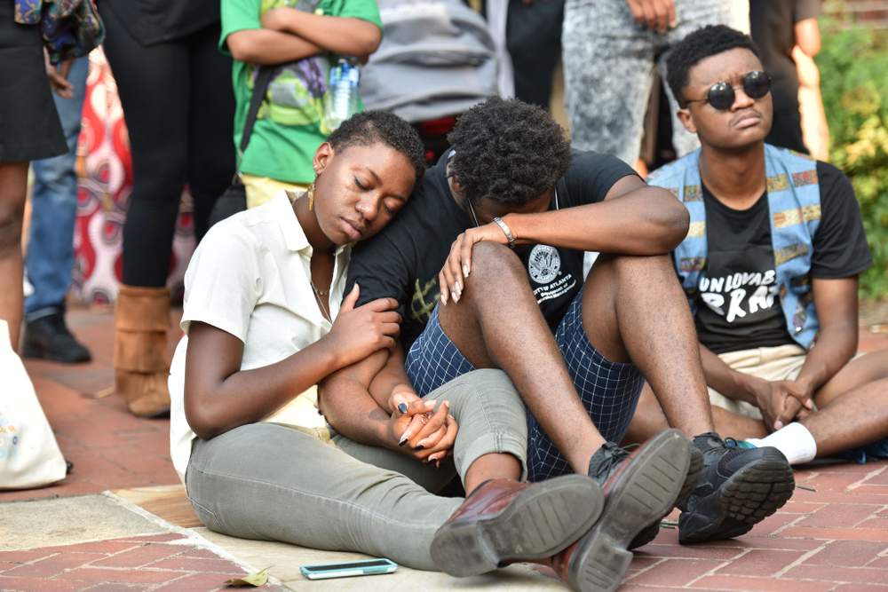 Eva Dickerson (left), a student at Spelman College, and MarTaze Gaines, a Morehouse College sudent, embrace during an August 2016 memorial on the Clark Atlanta University campus for former Clark Atlanta student Jamarion Robinson, who was shot and killed by law enforcement during an attempt to serve a warrant in July.PHOTO: Hyosub Shin \/ AJC