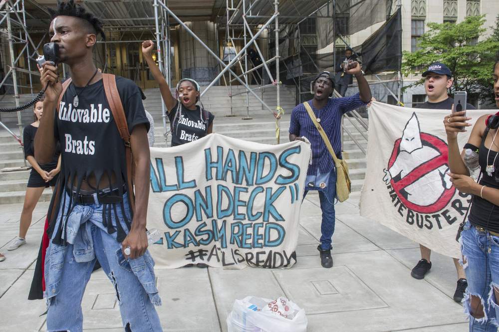 Avery Jackson, left, a student at Morehouse College, leads a chant as he, and others who have chosen to remain unidentified, protest outside Atlanta City Hall during a meeting between activists and Mayor Kasim Reed July 18, 2016.PHOTO: John Amis \/ Special