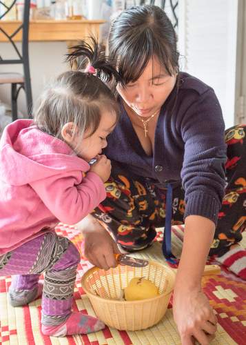 With the help of a neighbor’s child, Zil prepares a meal for her family. In addition to growing the family’s vegetables, she works two jobs to help support them.