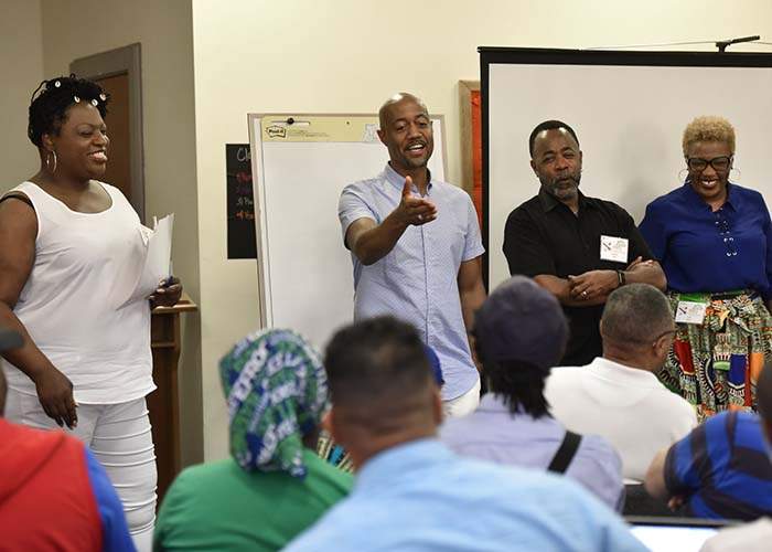 Craig Washington (standing second from left) leads a discussion about the experiences of HIV+ long-term survivors. 