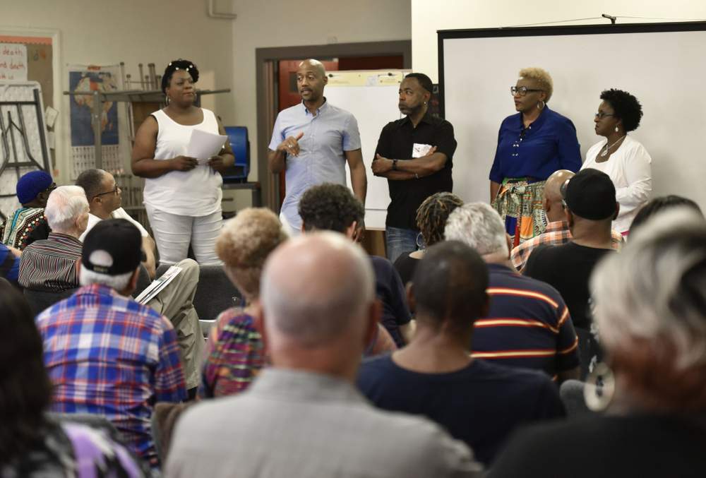 Craig Washington (standing second from left) leads a discussion about the experiences of HIV+ long-term survivors.
