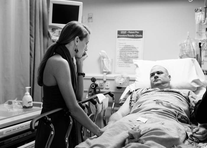 Jenna looks on as a nurse places an IV in Josh's arm.