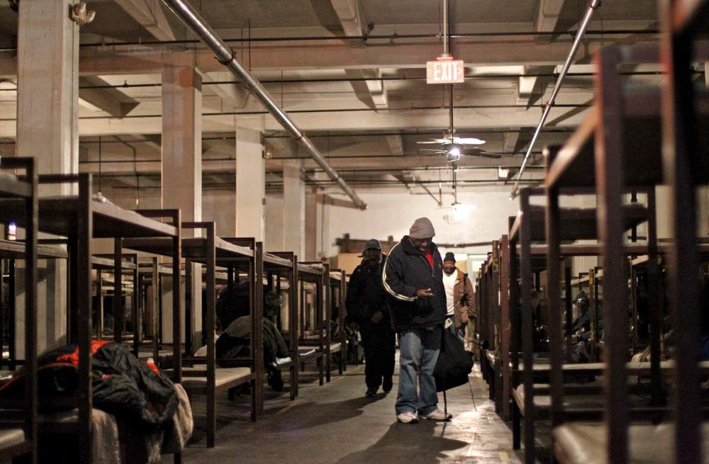 Men walk into the large sleeping room at the Peachtree-Pine shelter in 2011. \/ AJC file photo