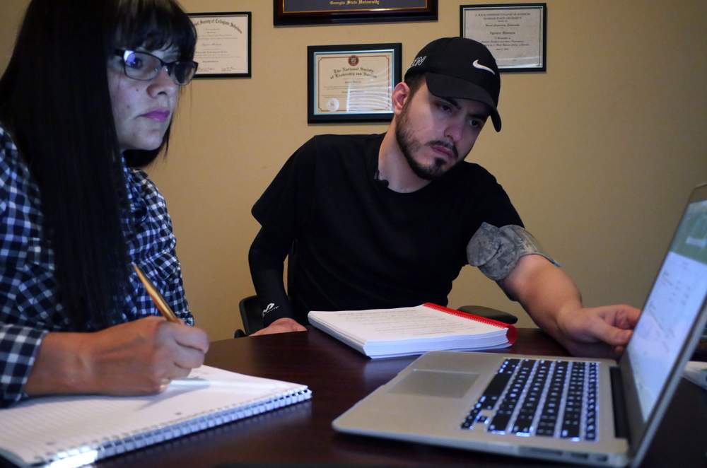 Alexandra Betancur (left) helps take notes for Ignacio as he studies for the GRE in hopes of attending graduate school. \/ Photo by Hyosub Shin \/ hshin@ajc.com