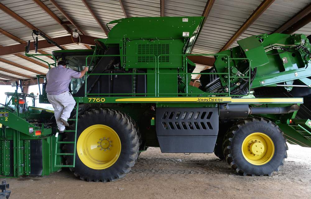 Matt Coley climbs aboard his John Deere cotton picker.  The machine,  with a price tag of  around $700,000, is the heart of the family farm.Photo: Brant Sanderlin / bsanderlin@ajc.com