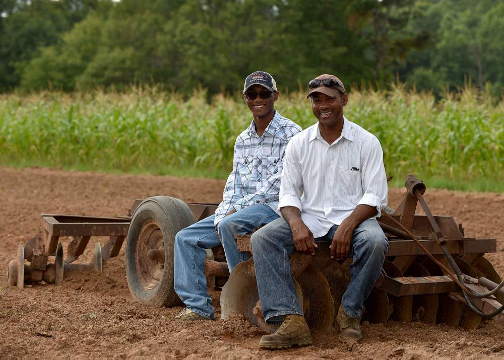 Addis L. Bugg (right), a retired Marine,  has returned to the family farm to try his hand at growing vegetables and raising cattle with his son Addis.  Photo: Brant Sanderlin / bsanderlin@ajc.com