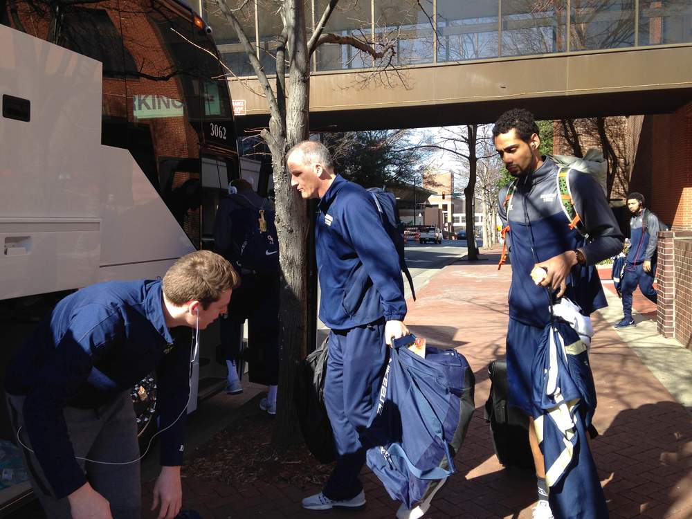 Georgia Tech assistant coach Eric Reveno and forward Quinton Stephens bring their bags to team manager Alex Fisher before getting on the team bus before the game. The team would leave from the arena to the airport after the game. (Ken Sugiura\/AJC)