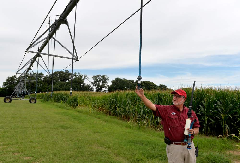 Calvin Perry, superintendent at Stripling Irrigation Research Park in Camilia Ga., checks a water nozzle on a water pivot.  The large contraption of pipes and nozzles that rotates around a field to provide water for crops has been around for decades, but updates in technology is making their use more efficient. (Brant Sanderlin\/bsanderlin@ajc.com)