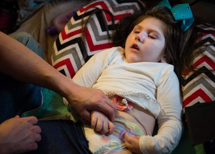 Brian holds Haleigh's hand as the seven-year-old receives insulin for diabetes.