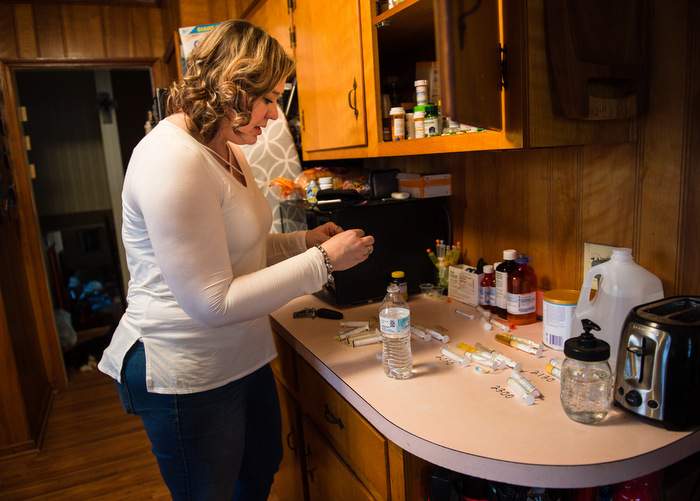 Janea Cox prepares medications and vitamins for Haleigh.
