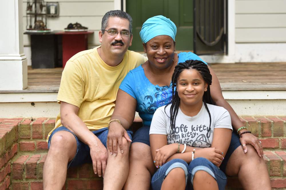 Jinaki and Greg Flint sit with their daughter Mahalia,  13,  at their home in Atlanta. HYOSUB SHIN / HSHIN@AJC.COM