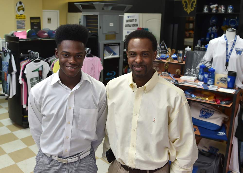 Mike Washington (right) and his son, Kevan, at the Up Up &amp; Away Printing in Smyrna.  BRANT SANDERLIN/BSANDERLIN@AJC.COM