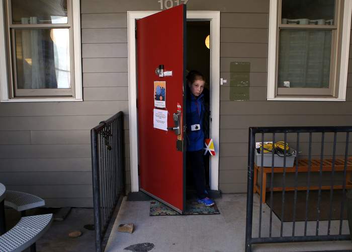 Gabriel emerges from the front door of Connections School of Atlanta. 
