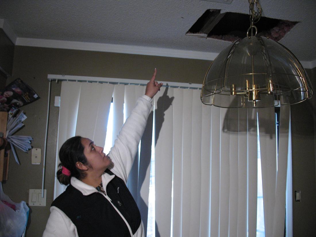 Marlen Martinez points toward the area where a stray bullet from celebratory gunfire ended up in her family's home.Andria Simmons / AJC File