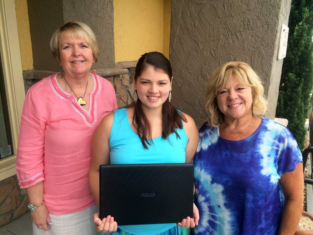 Holly Comer, left, and Kim Gresh, right surprised Felicia Villegas with a laptop she can use for schoolwork when she enrolls at Kennesaw State University. Photo: Jennifer Brett