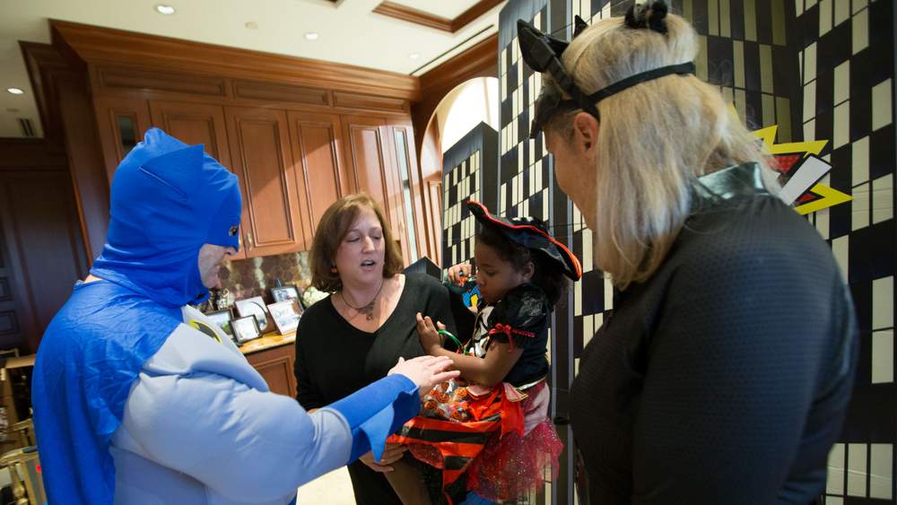 Melody and Rick Jackson dressed as Batgirl and Batman to hand out candy. Branden Camp