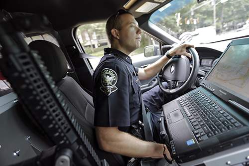 Troy Cosby responds to a report of drug dealers at a laundromat. As a Tactical Field Operator, he is equipped with additional tactical equipment, including a rifle (seen here at left) and breaching equipment. (BOB ANDRES \/ bandres@ajc.com)