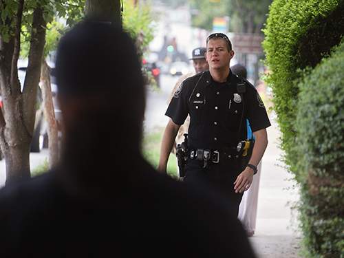 APD officer Troy Cosby searches for a man who was allegedly cashing a disturbance on private property. (BOB ANDRES \/ bandres@ajc.com)