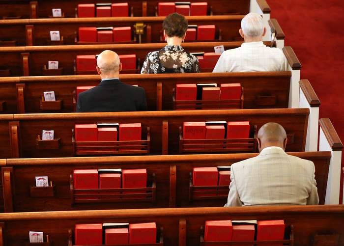 Members bow their heads for the opening prayer at Clarkston United Methodist Church on Sunday, Sept. 18, 2016.