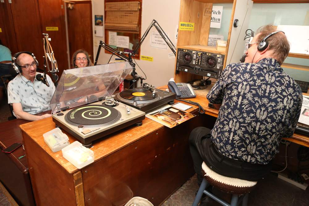 Greg Germani, with the assist of girlfriend Beth Anne Harrill, is back on the air as guest host the Sagebrush Boogie on WRFG radio station with Dave Chamberlain. (Akili-Casundria Ramsess/Special to the AJC)
