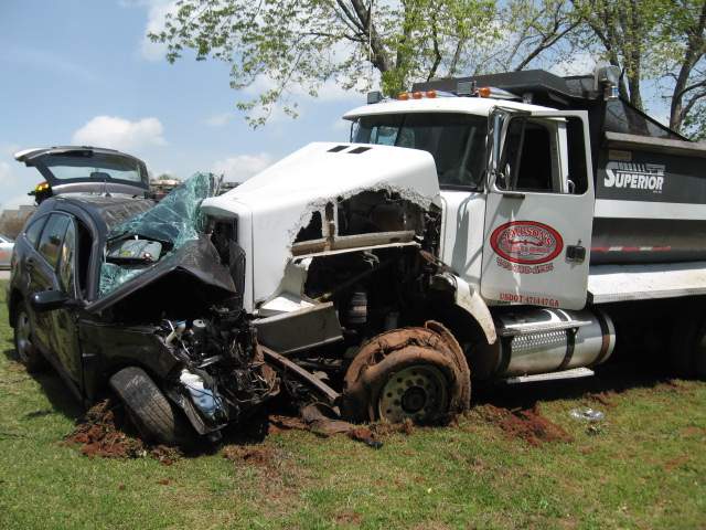 The dump truck and Cooper's Honda CR-V went off the road, crossing a front yard and striking a golf cart.