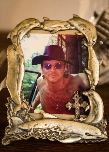 His mother keeps the cross Steve is seen wearing in this photo with the picture at her Acworth home. 